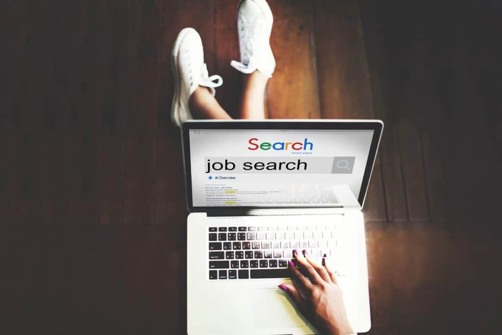 Person sucht auf einem Laptop nach Jobs mit Hilfe von der KI-Suche