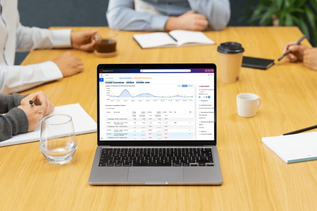 Laptop mit Salesware-Analyse auf einem Konferenztisch während eines Business-Meetings