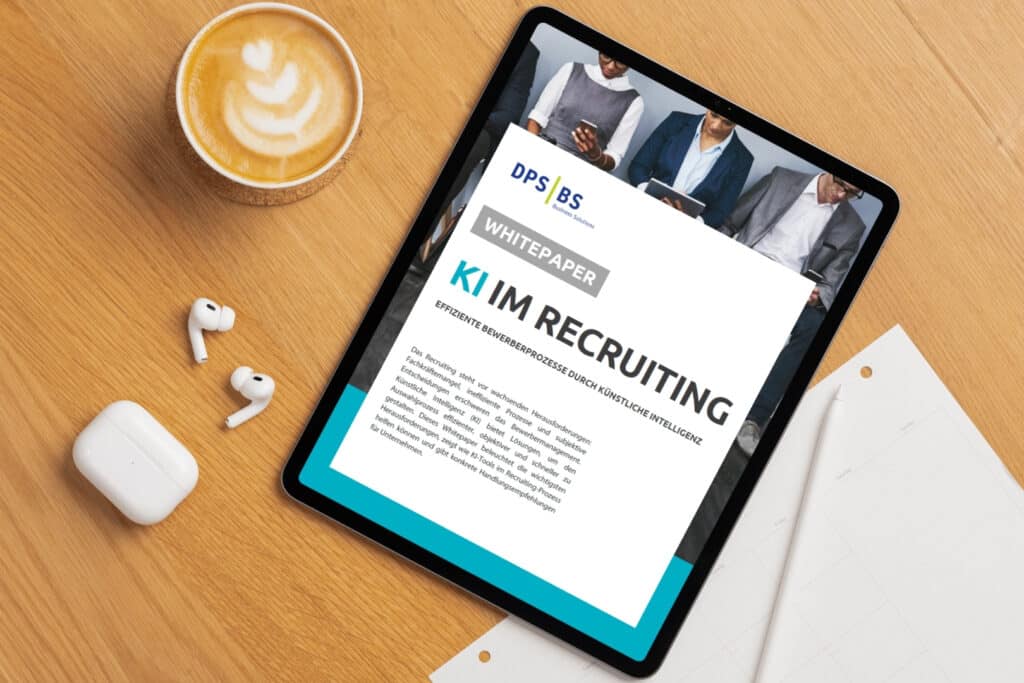 Tablet mit Whitepaper zu KI im Recruiting auf einem Schreibtisch neben Kaffee und Kopfhörern